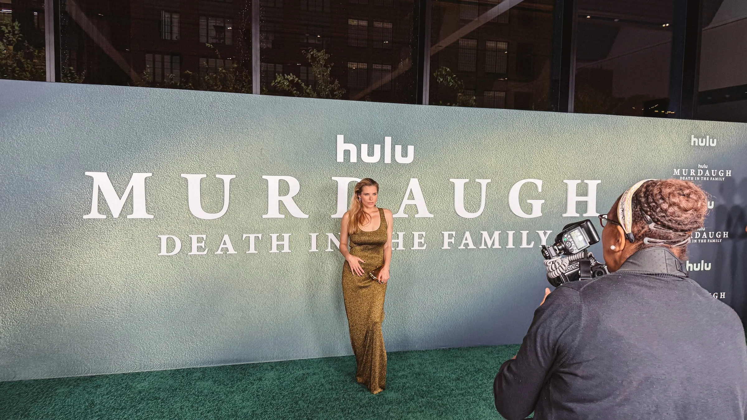 A red-carpet step-and-repeat for Hulu’s Murdaugh: Death in the Family with a green stag head