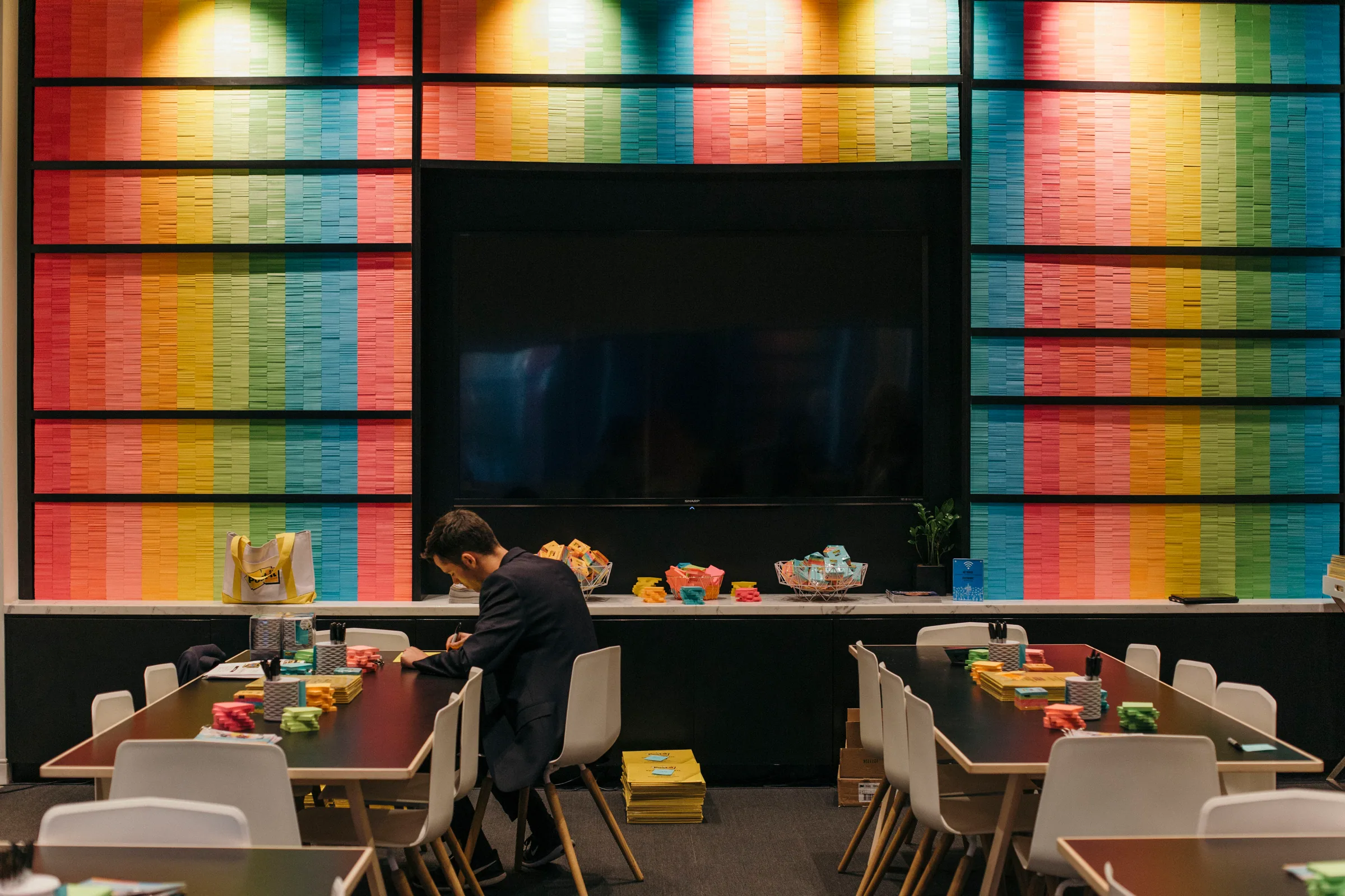 A Post-it note wall in rainbow color bands