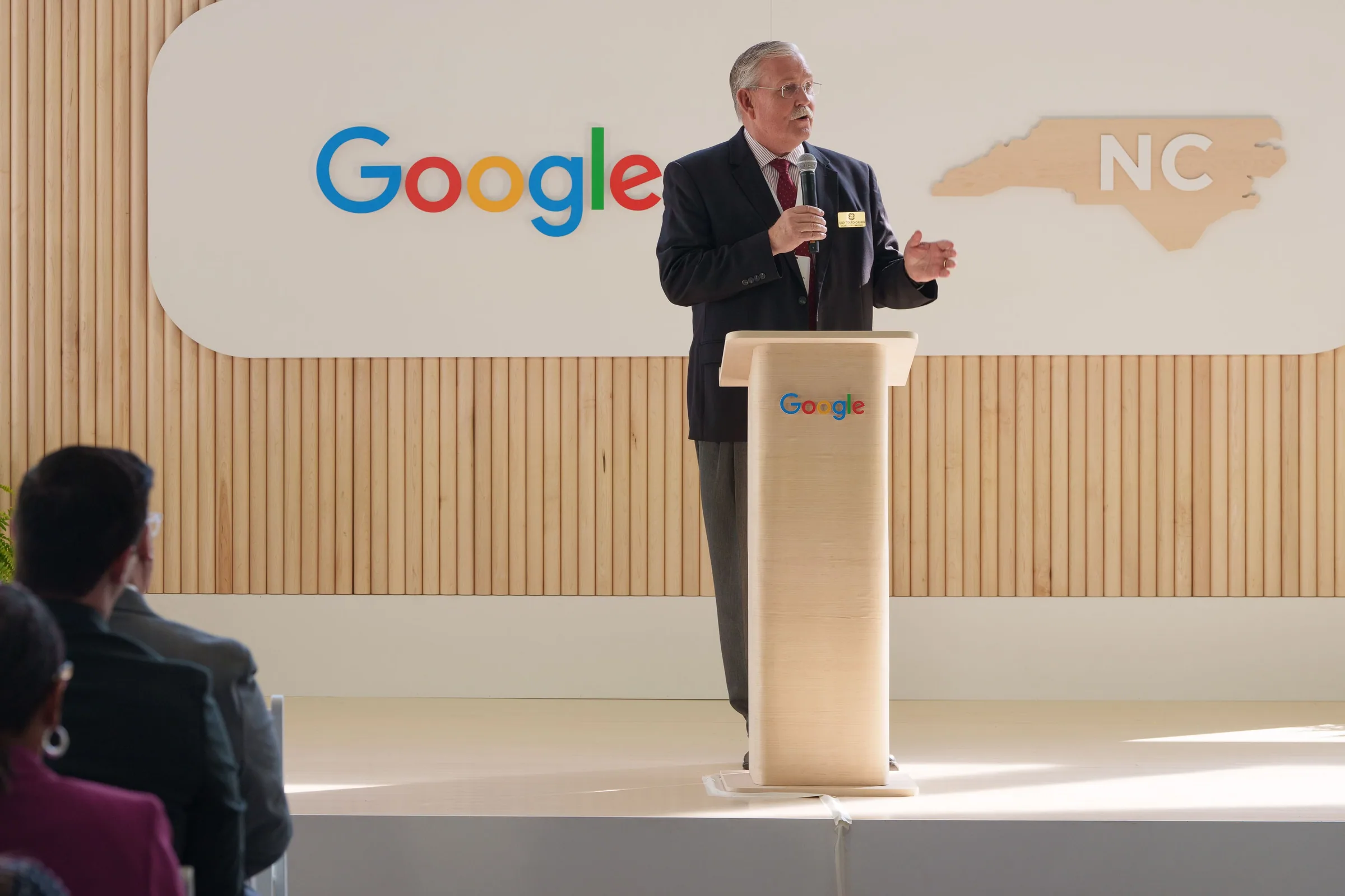 A speaker at a wood podium in front of the Google and North Carolina mark
