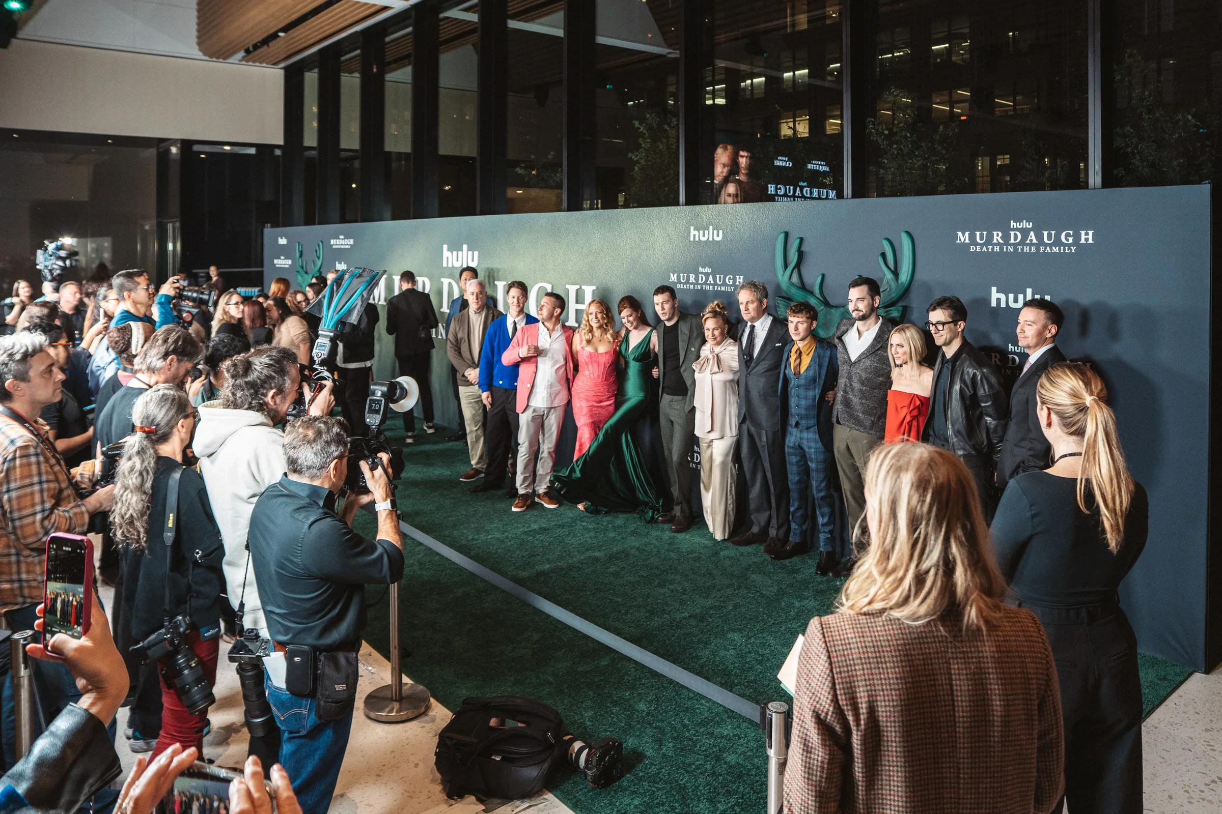 The cast lined up in front of the stag wall facing the press