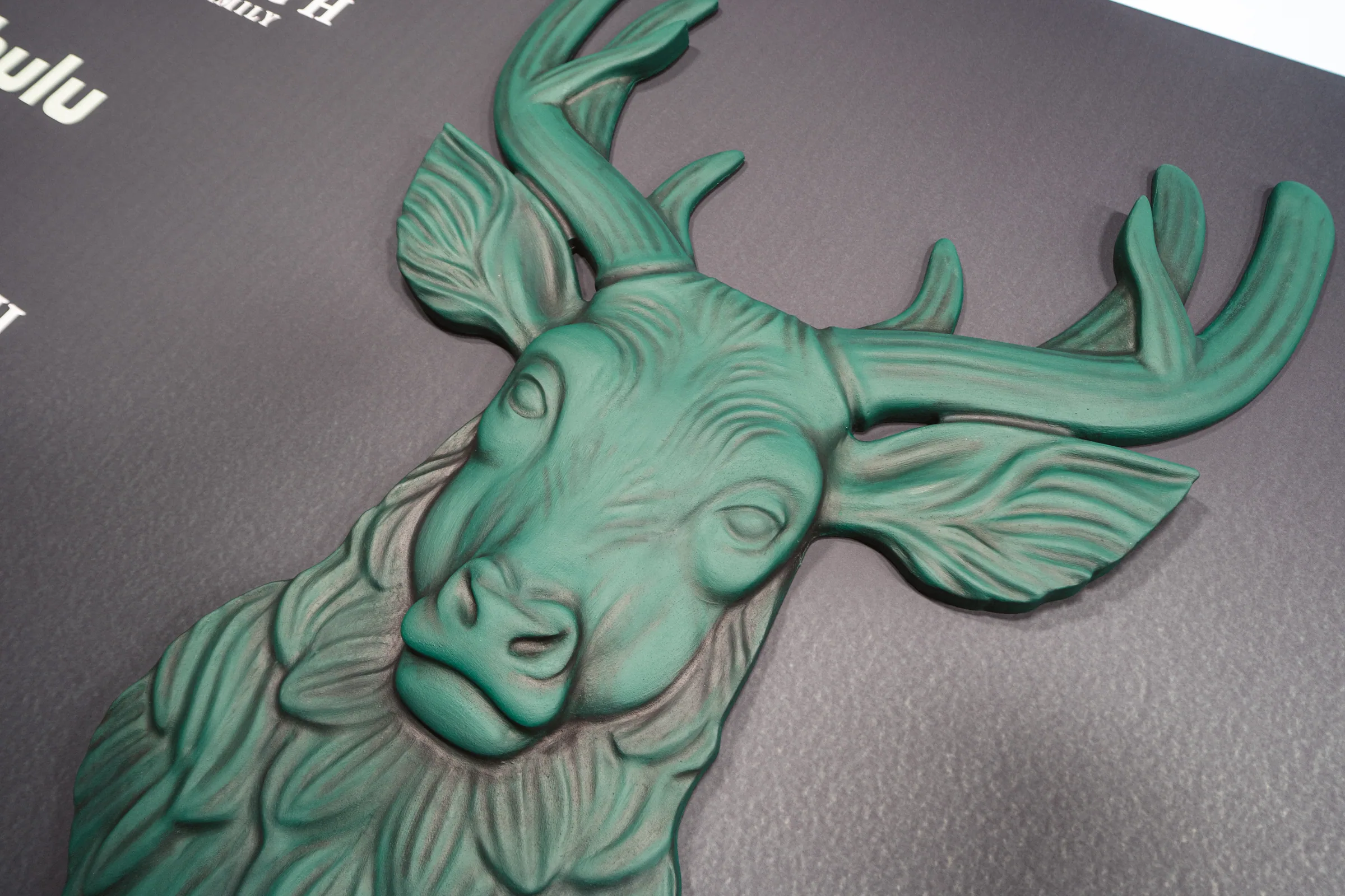 The painted stag head relief up close