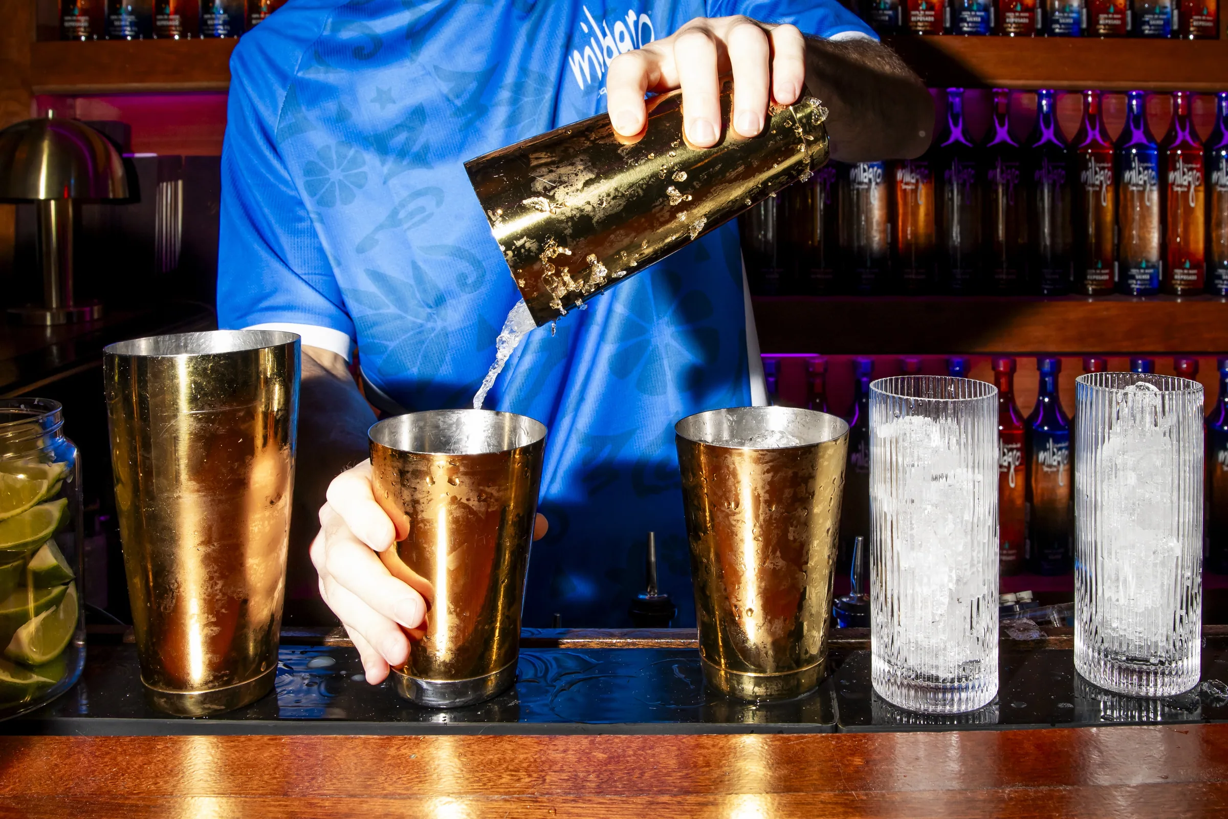 A bartender in a Milagro jersey pouring cocktails