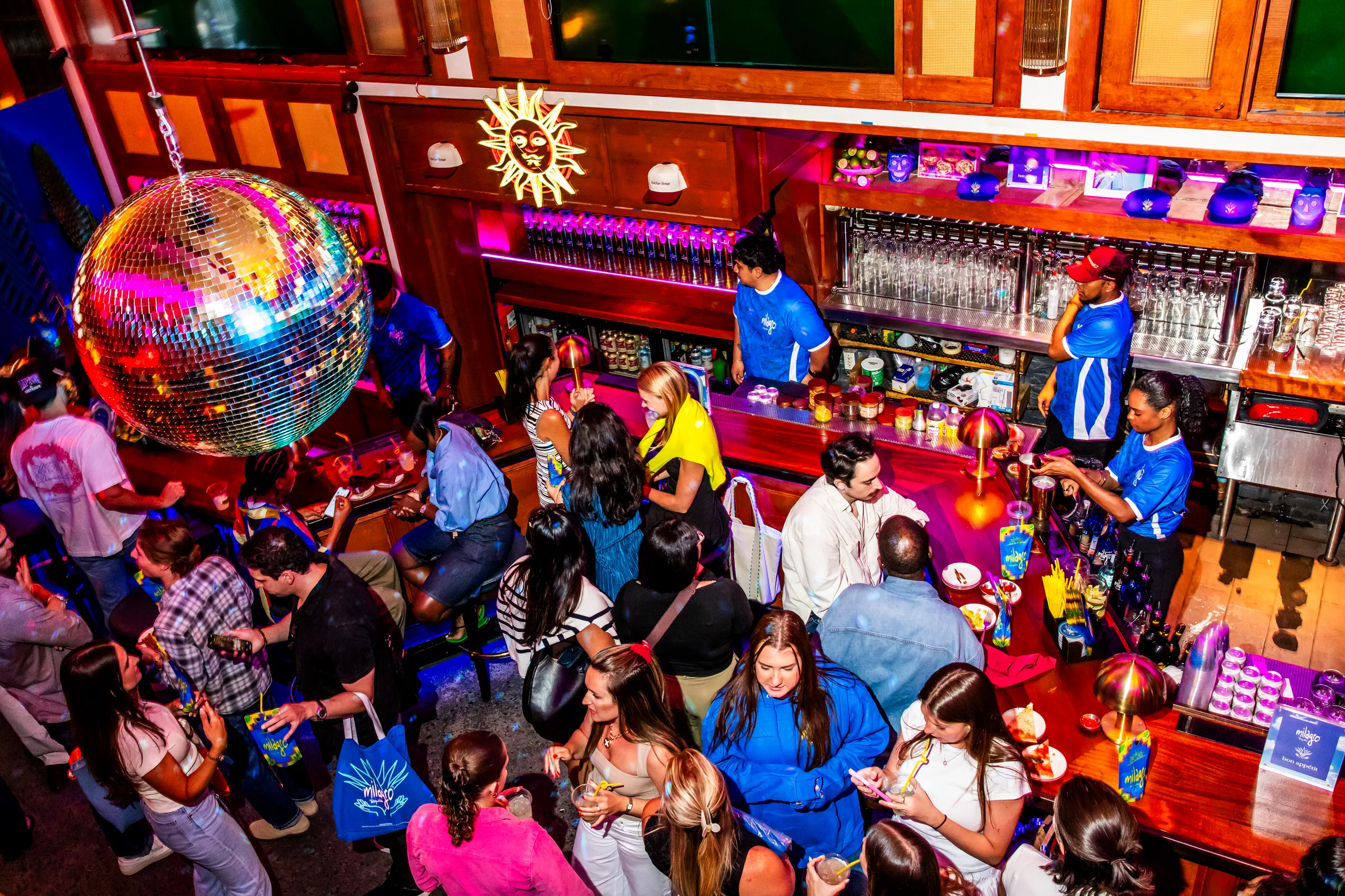 A crowd under a disco ball at a Milagro and Bon Appétit World Cup party