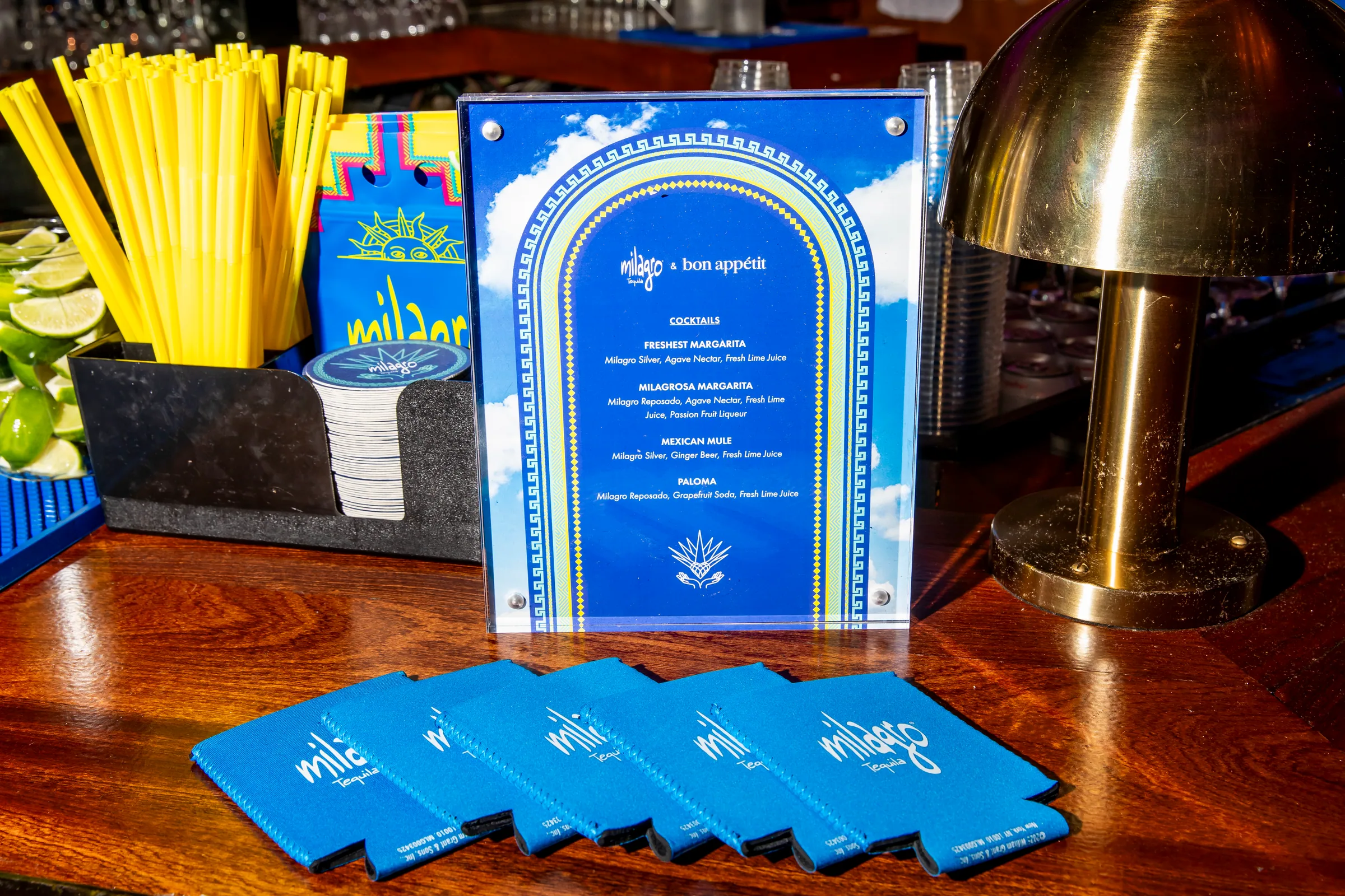 A menu card in an arch frame with blue koozies