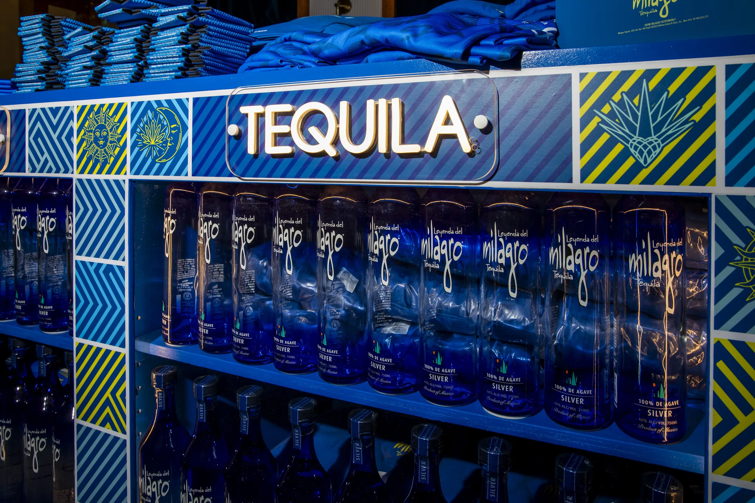 Bottles and jerseys on the patterned merch bar