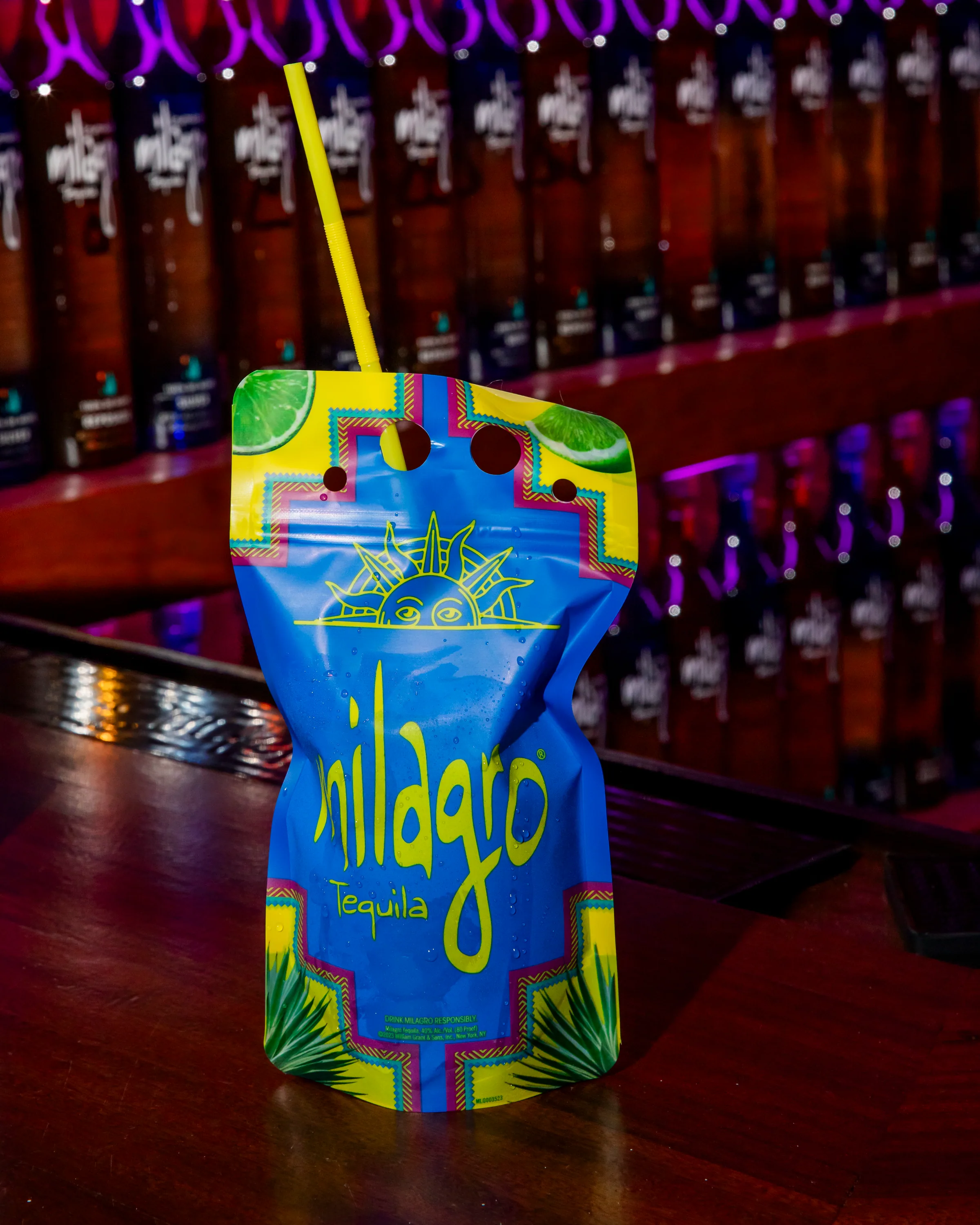 A Milagro cocktail pouch with a yellow straw